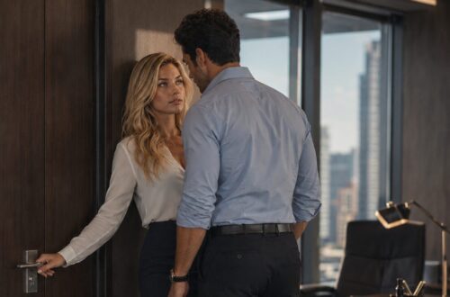 Blonde woman and dark-haired man kissing in a modern office