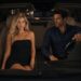 Blonde woman and dark-haired man sitting in a car at night while the man drives