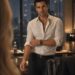 Blonde businesswoman facing a dark-haired man alone in a modern office after hours