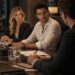 Blonde businesswoman and dark-haired man during a tense corporate meeting