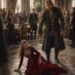 Lili and King Mark during a dramatic moment in a crowded castle hall