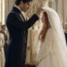 Aiden gently lifting Tess's bridal veil during their wedding ceremony inside a church