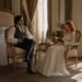 Aiden and Tess sitting opposite each other with books in an elegant sunlit bedroom