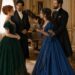 Tess and Aiden facing another elegantly dressed couple beside a grand piano