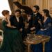 Tess, Aiden and two guests sharing wine and conversation in an elegant drawing room