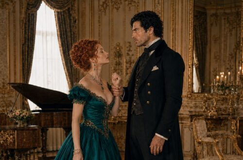 Aiden holding Viktoria's wrist as she confronts him in an emerald evening gown