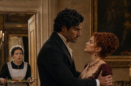 Aiden gripping a red-haired woman's shoulders as a shocked maid enters the dining room